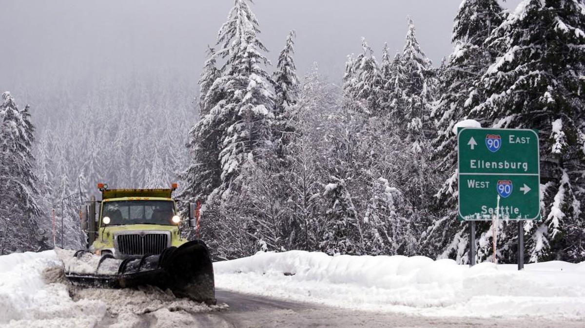 A snowplow clears an overpass of freshly fallen snow over Interstate 90 at Snoqualmie Pass in 2015.