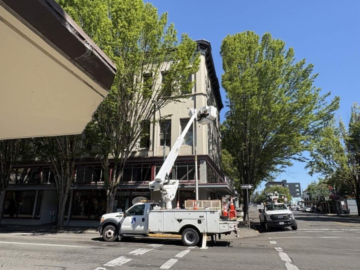 A repair truck replaces a traffic pole following a collision early Monday morning at Capitol Way and Fourth Avenue, where a vehicle collided with a traffic signal pole and its box, disabling all four traffic lights in the intersection.