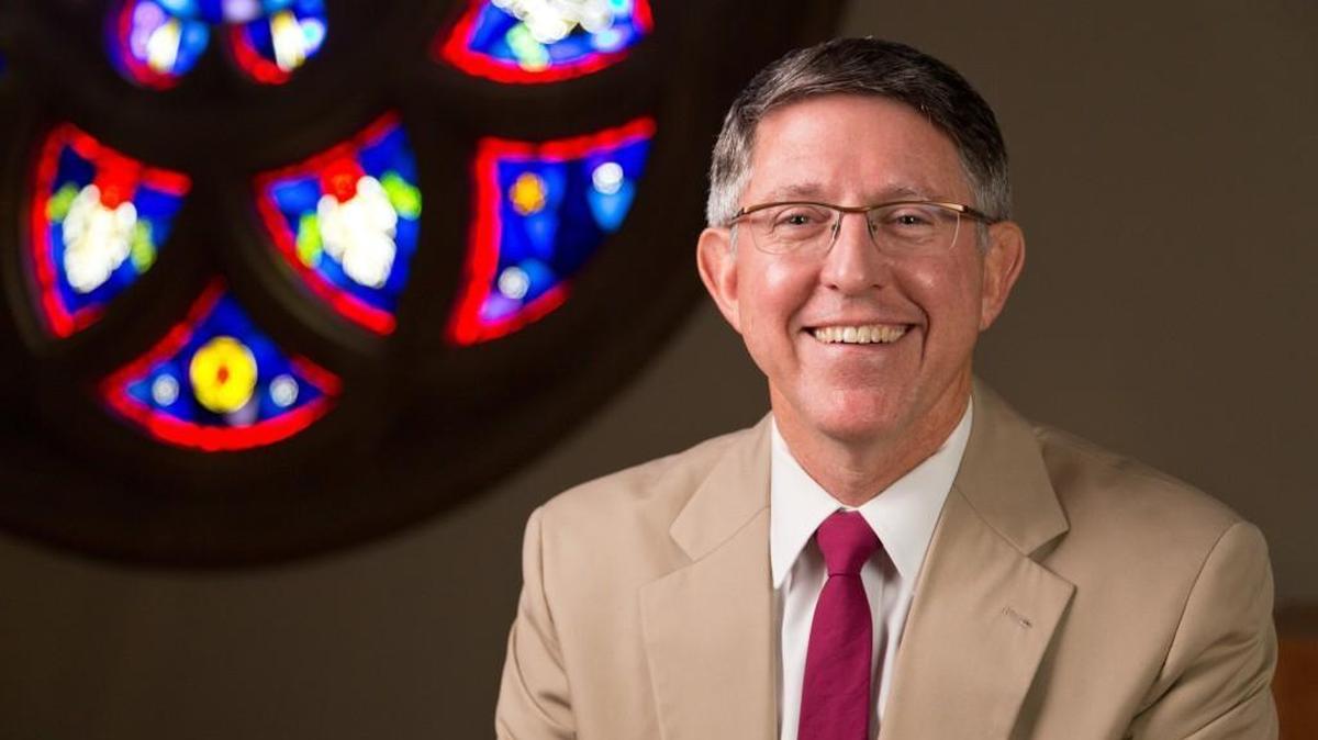 Pacific Lutheran University President Thomas Krise sits in front of the rose window in the Ness Family Chapel of the Karen Hille Phillips Center at PLU on Aug. 21, 2014.