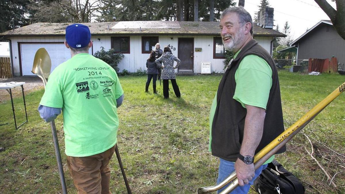 Tim Stendor (right) of Olympia, a construction teacher with the Youth Build program at New Market Skills Center in Tumwater, arrives with former Youth Build student Casey Reeves (left) of Lacey during the Homes First groundbreaking ceremony for its newest project home on X Street in Tumwater on March 31.