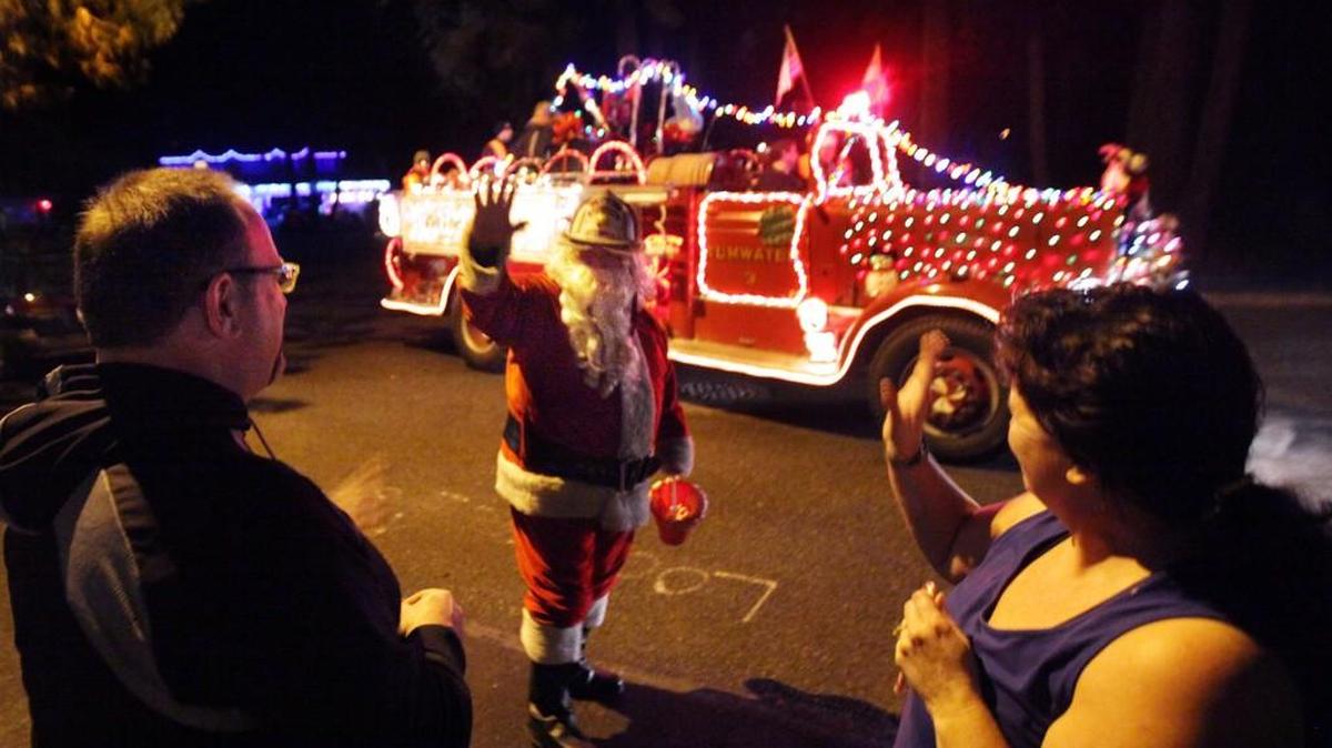 Lyall Smith, aka St. Nick, joins a cadre of Tumwater Fire Department volunteers and family friends in 2013 as they pick-up a Thurston County Food Bank donations as part of their annual holiday Santamobile neighborhood visits. At least two Santamobiles are visiting neighborhoods this week.