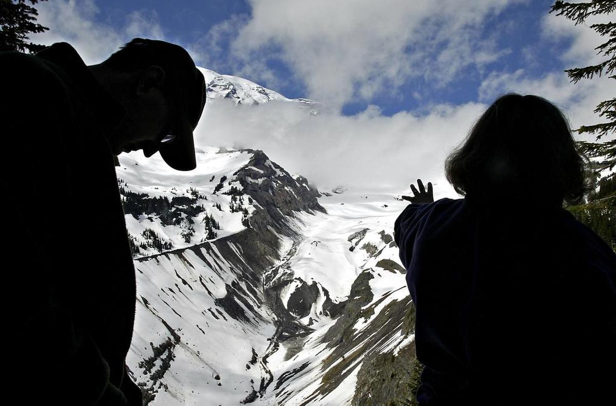 US Geological Survey scientist Carolyn Driedger, right, and Mount Rainier National Park ranger Scott Beason frame the terminus of the Nisqually Glacier during a training session for seasonal rangers at the park on Mount Rainier in 2008.