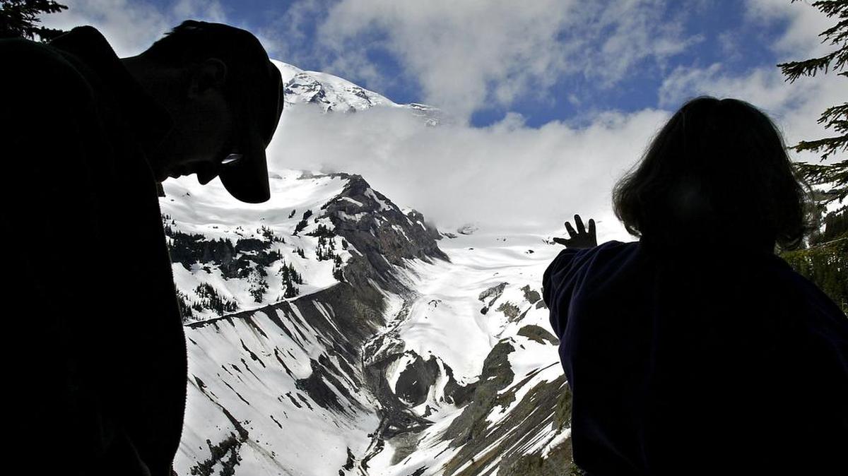 USGS scientist Carolyn Driedger, right, and Mount Rainier National Park ranger Scott Beason frame the terminus of the Nisqually Glacier during a training session for seasonal rangers at the park on Mount Rainier, Wash., June 2, 2008. Beason measured the river beds before and after the flood for his master’s thesis and Driedger was a witness to a spectacular debris flow at the park in 2001. Researchers at the park are studying the possible connection between increased debris flows and rates of aggradation in Rainier’s glacially fed rivers and global warming. (AP Photo/The News Tribune, Dean J. Koepfler