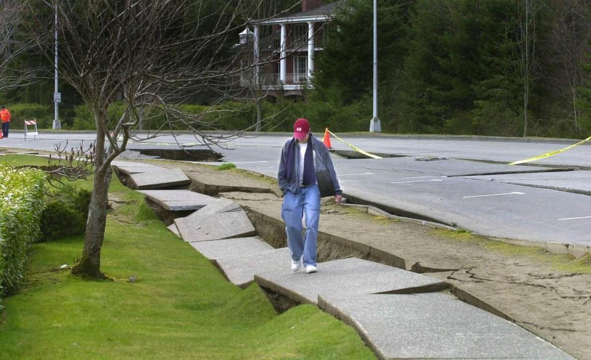 A pedestrian navigates damage along the Deschutes Parkway after the 2001 Nisqually earthquake.