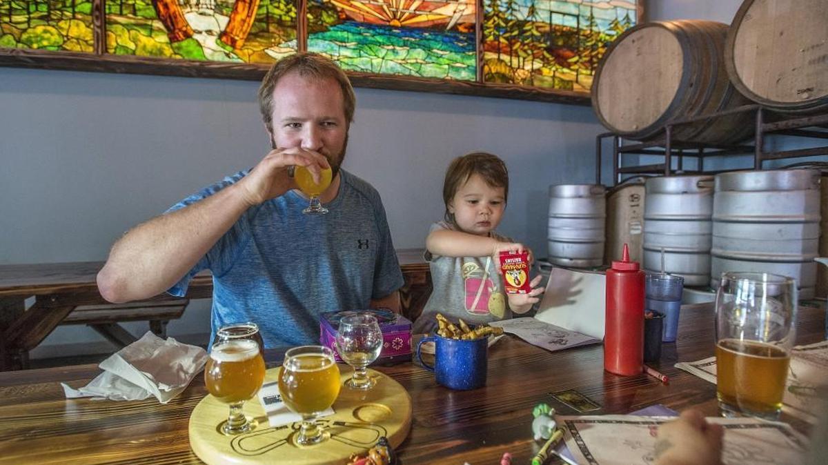 The family friendly atmosphere at Three Magnets Brewing Co. in Olympia means dad, Matthew Hanson can enjoy a sampling of distinctive beers while daughter Brynn, 3, can color and eat french fries served in a cup. The pub has a history trivia night Thursday.