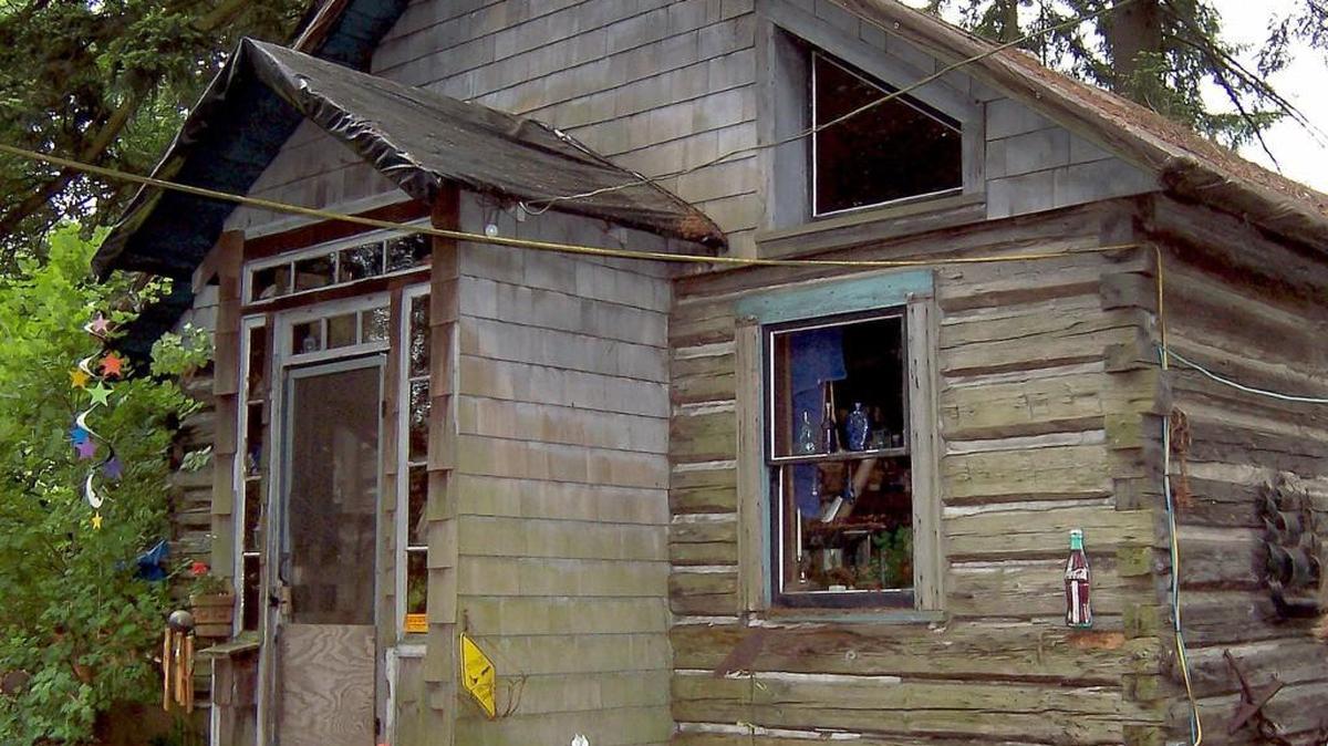 A pre-deconstructed photo of the Chambers Prairie log cabin shows its vintage design.
