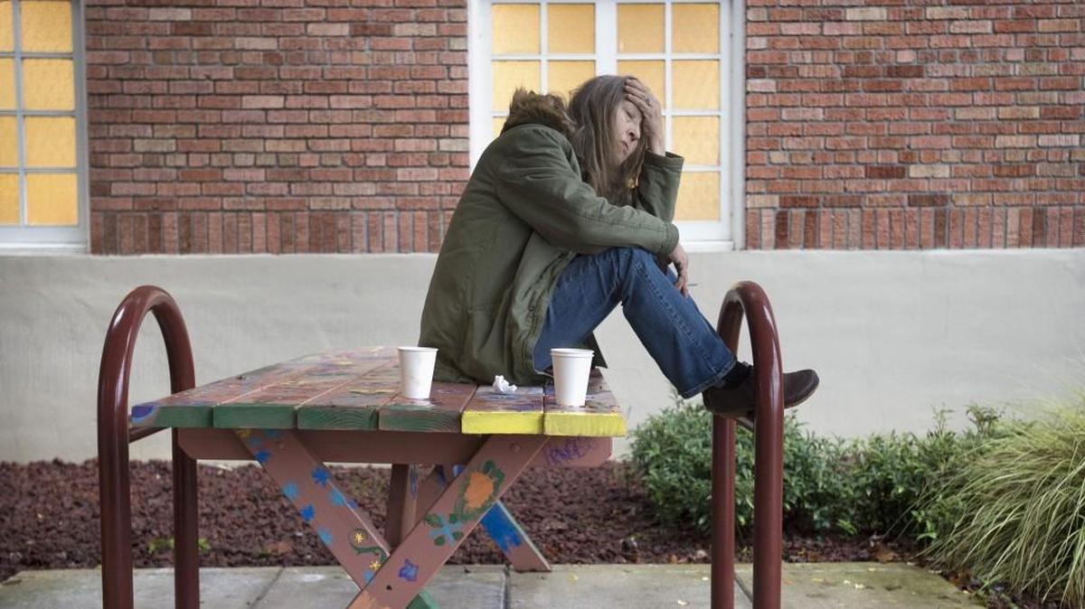 Kathleen Gallaher sits outside the Interfaith Works Winter Warming Center at Temple Beth Hatfiloh — one of three downtown Olympia churches that split the daily daytime centers operations — in December. “I don’t want to die homeless,” Gallaher said. “I’m 62 years old. I can’t do this forever.”