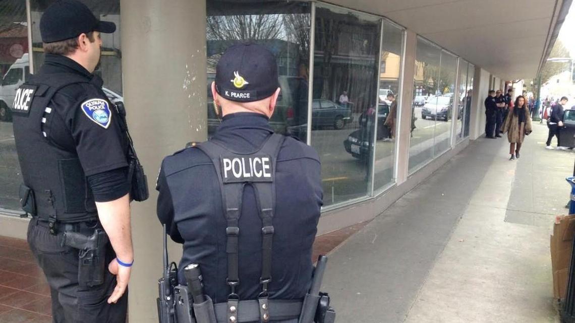 Olympia police stand watch at Capitol Way and Fourth Avenue in downtown Olympia Monday morning after a homeless advocacy group camped overnight near that location. Police asked them to move and they did.