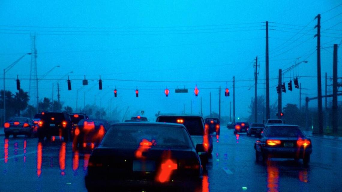 There is no law governing the distance cars should maintain while at a stoplight, but a smart distance is one that lets you get past the car in front of you in an emergency situation.