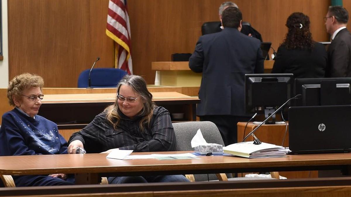 Debbie Lattin pours a glass of water for her mother, Carolyn, as attorneys confer with Judge Sam Meyer during the jury selection process Dec. 4 on the opening day of their trial on second-degree animal cruelty charges at the Thurston County courthouse.