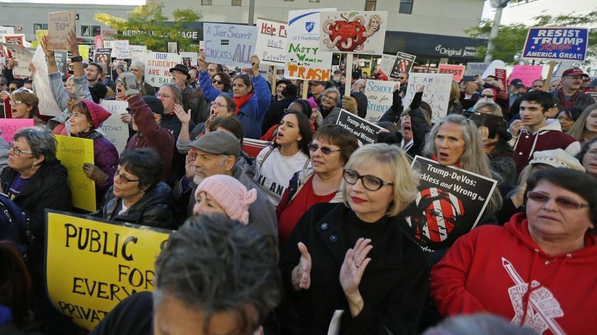Protesters cheer during a protest rally against U.S. Education Secretary Betsy DeVos on Friday outside the Bellebue hotel where DeVos was scheduled to speak later in the evening.