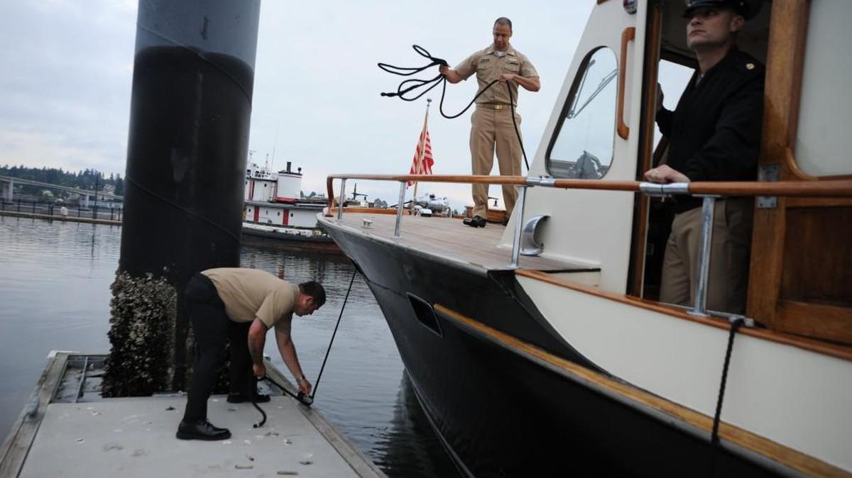 Navy Region Northwest Sailors moor the command cutter, Old Man IV, at Bremerton Marina in 2014. The 50-foot admiral’s barge will be the featured boat the Wooden Boat Fair in Olympia.