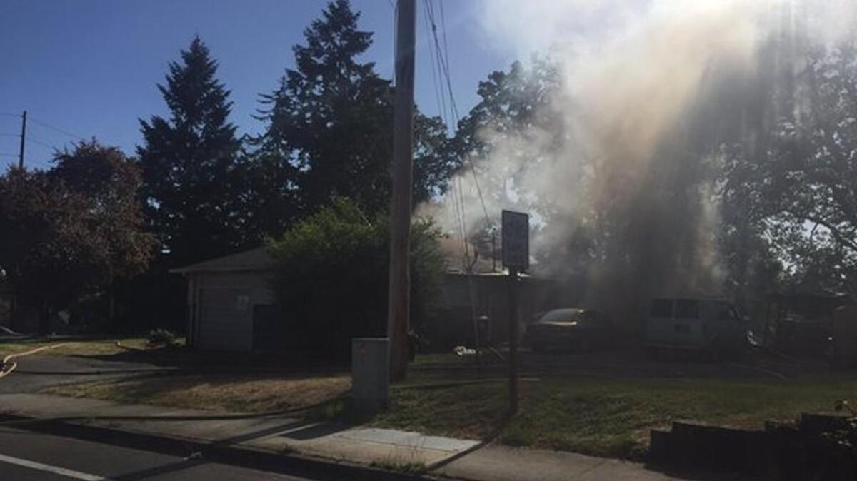 Smoke rises from a house on Marvin Road Southeast in Lacey after firefighters knocked down a blaze there Wednesday afternoon.
