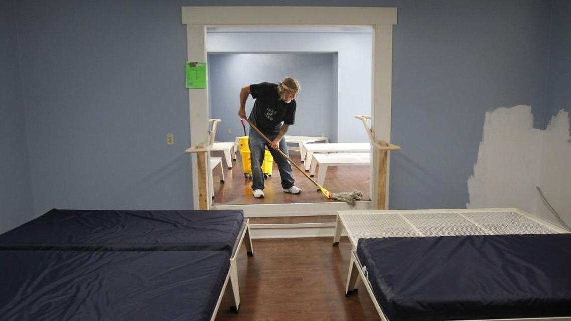 Support staff worker Dave Wade of Olympia gives the new laminate floors a final cleaning as he helps prepare for the opening night of the Interfaith Works Overnight Emergency Shelter in the basement of the First Christian Church in downtown Olympia on Saturday, Nov. 1, 2014. The shelter features 42 beds for both men and women in separated dorms.