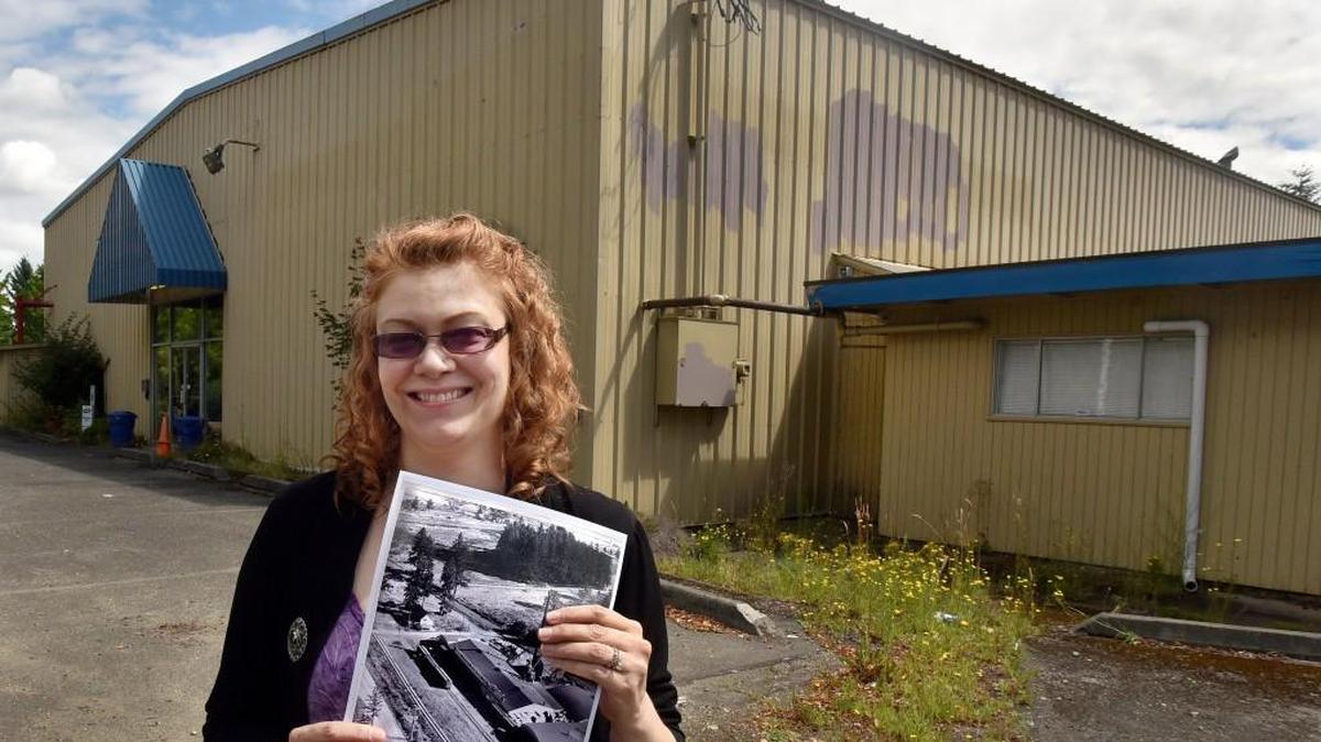 Lacey Museum curator Erin Quinn Valcho stands at the former location of the Lacey Plywood Co. and a now-defunct carpet business in 2016. On Thursday, Lacey City Council voted to award a contract to demolish that building behind her to make way for the new Lacey Museum & Cultural Center.
