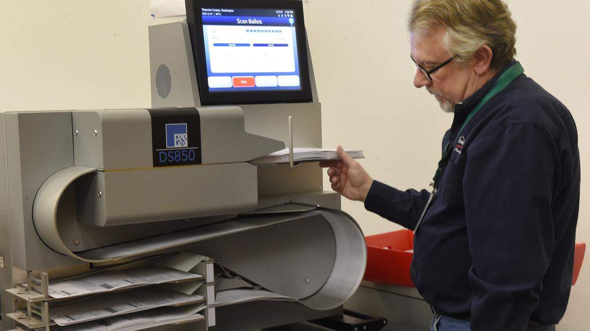 Election technician Tony Wickie runs a group of ballots through a scanning system at the Thurston County Elections Shop Tuesday afternoon.