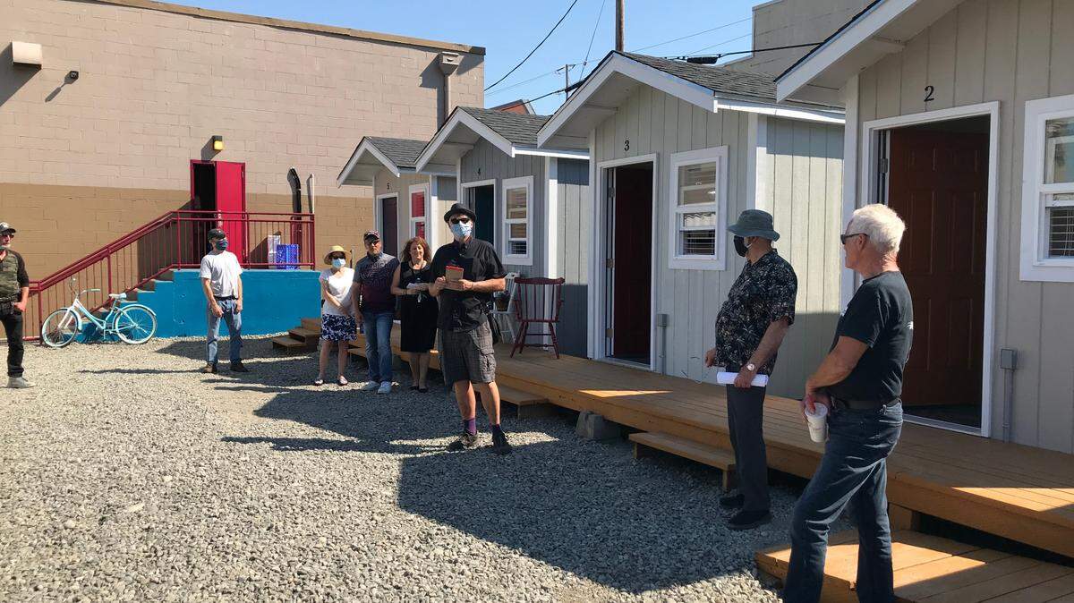 Olympia Rotary Club Partnership Lead Paul Knox talks about how volunteers worked with students from YouthBuild and Olympia Union Gospel Mission to construct five tiny homes. To his right: Skip Steffen and Jack Olson of UGM. To his left: Jackie Smith, UGM volunteer who selected tenants and will serve as their “mentor.”