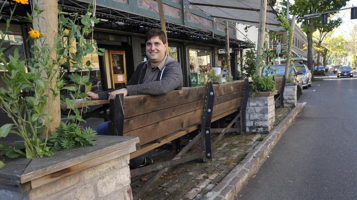 
Olympia downtown liaison Brian Wilson sits Tuesday one of the “parklets” his efforts helped produce in the city. The parklet outside Buck’s Fifth Avenue spice shop on Fifth Avenue between Washington and Franklin streets, is one of many improvements Wilson helped usher in.


