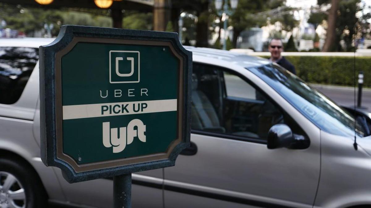In this Jan. 14, 2016, photo, a driver waits to pick up passengers at an Uber and Lyft pick up area at the Bellagio hotel and casino in Las Vegas. The advent of Uber and Lyft in Nevada last fall has thrown the powerful Las Vegas taxi industry and its regulators into upheaval, as the taxi industry's $3-per-ride credit card processing fee and lack of an online review system look suddenly out of date.