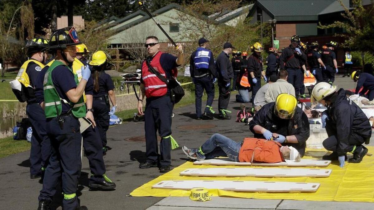 Holding a small GoPro-style video camera Olympia firefighter Jim Brown of the Olympia Fire Dept. takes training videos as emergency responders from nearly 30 regional agencies descended upon the Sound Puget Sound Community College campus for an active shooter drill. Appropriately named "Fools Rush In: Active Shooter exercise" for the April 1, 2015 event, the drill tested multiple agency response coordination using a scenario featuring shooters who have taken over several college buildings while killing and wounding a number of student and staff. Also utilizing volunteer "casualties" to replicate the drill shooting victims feedback and training data from the exercise will be later analyzed used as teaching tools for the various agencies.