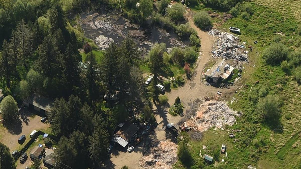 An aerial view of the Franks property at 2921 54th Ave. SW in Tumwater. Piles of wood and garbage are seen.