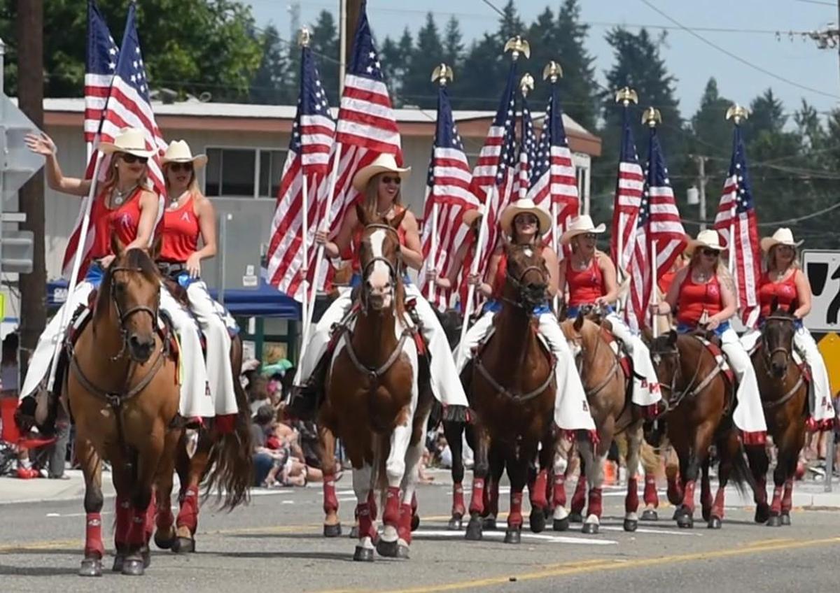 Resplendent in red, white and blue, the American Made Drill Rodeo wave to the thousands of spectators who lined Capitol Boulevard for the 2017 Tumwater Fourth of July parade.