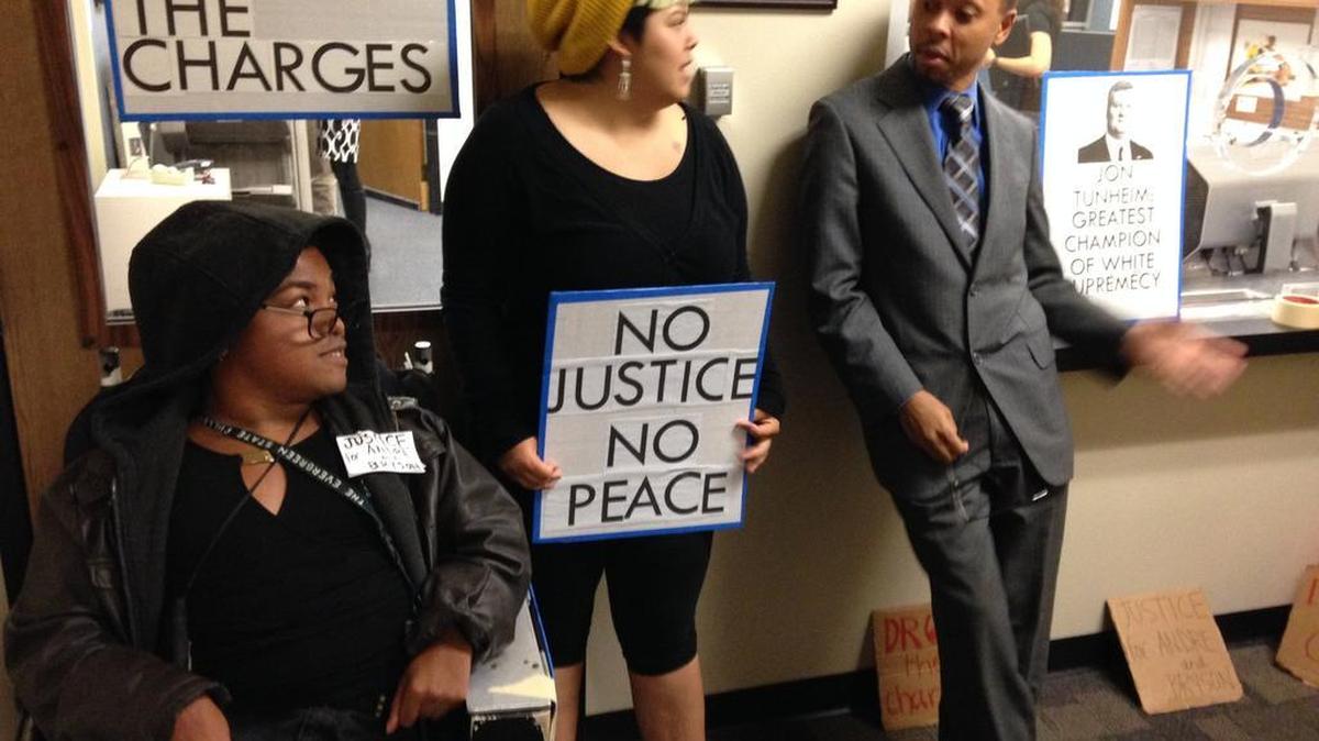 Rasaki Lee Vandrush, from left, and Caro Gonzales talk with public defender Larry Jefferson during a protest outside the Thurston County Prosecuting Attorney’s Office at the county courthouse in Olympia.