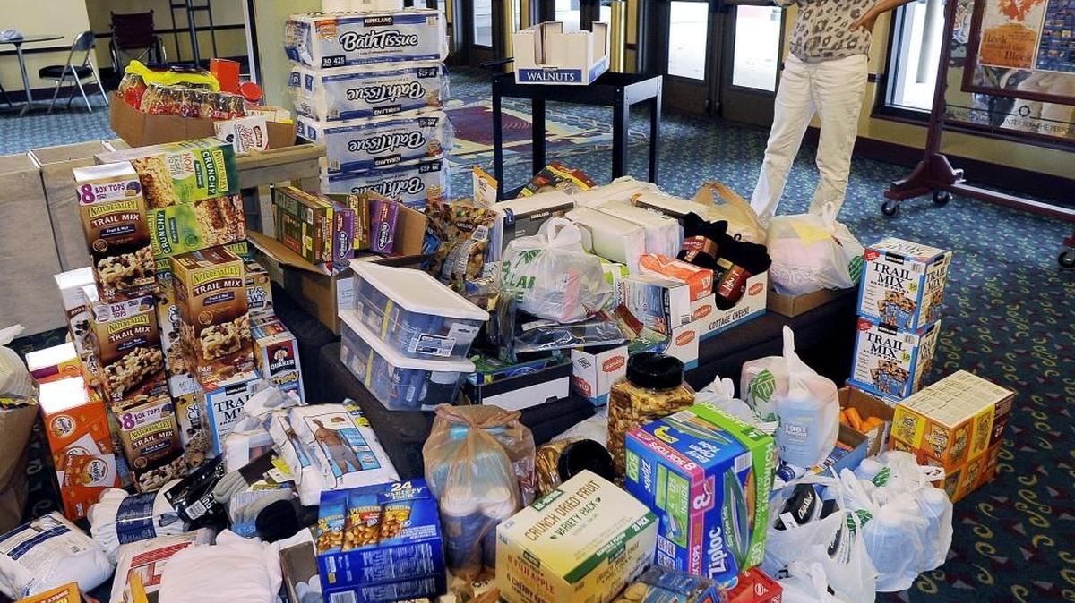 
Anne Larsen, marketing director for the Washington Center for the Performing Arts, shows the donated supplies, including more than  80 cases of juice and water, which had  been dropped off in their main lobby by Monday. All of the collected donations are being trucked to firefighters in eastern Washington
