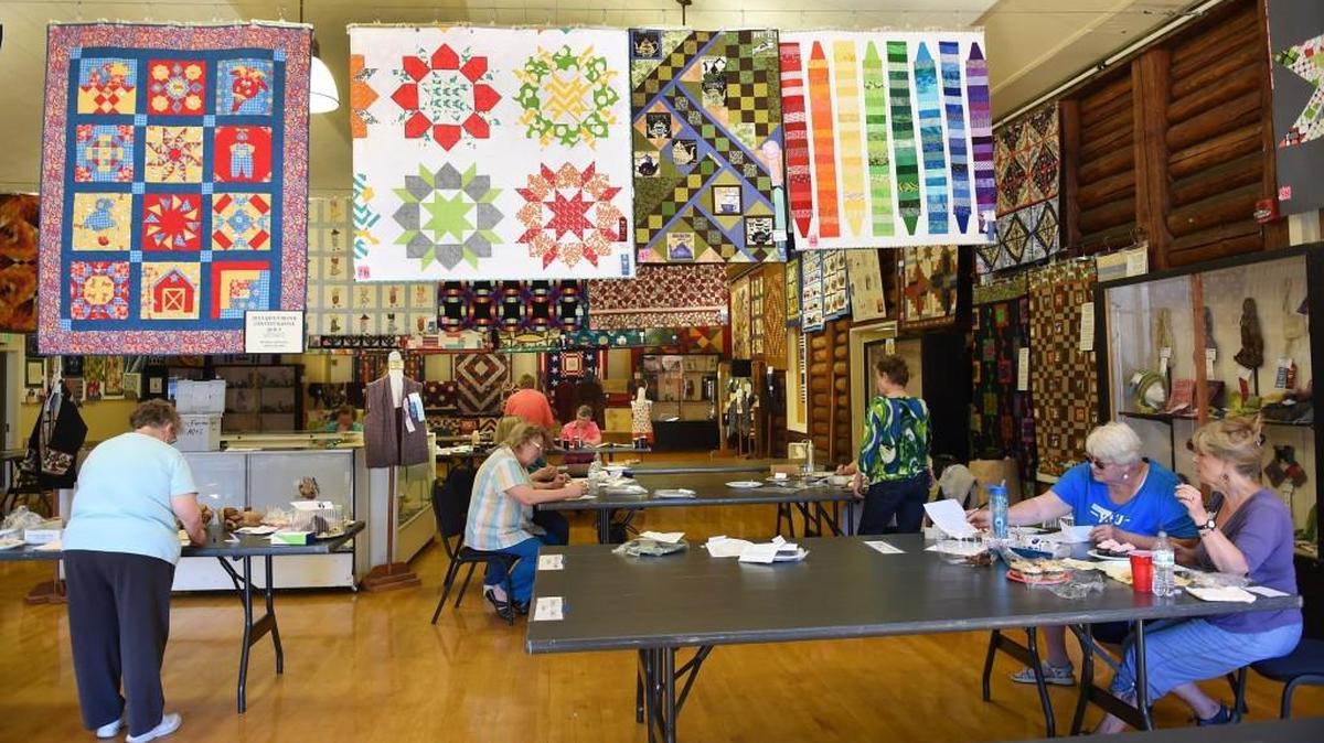 With colorful quilt entries hanging above judges for the food and baking competitions work in the Heritage Hall main room on July 28th in preparation of the opening of the 2015 Thurston County Fair. The fair runs through Sunday.