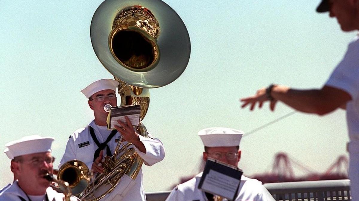 Members of the Navy Band Northwest follow director Lt. Ken Collins, right, during a performance along the waterfront in Seattle as five vessels from the Navy fleet arrive in Elliot Bay on July 31, 2002.