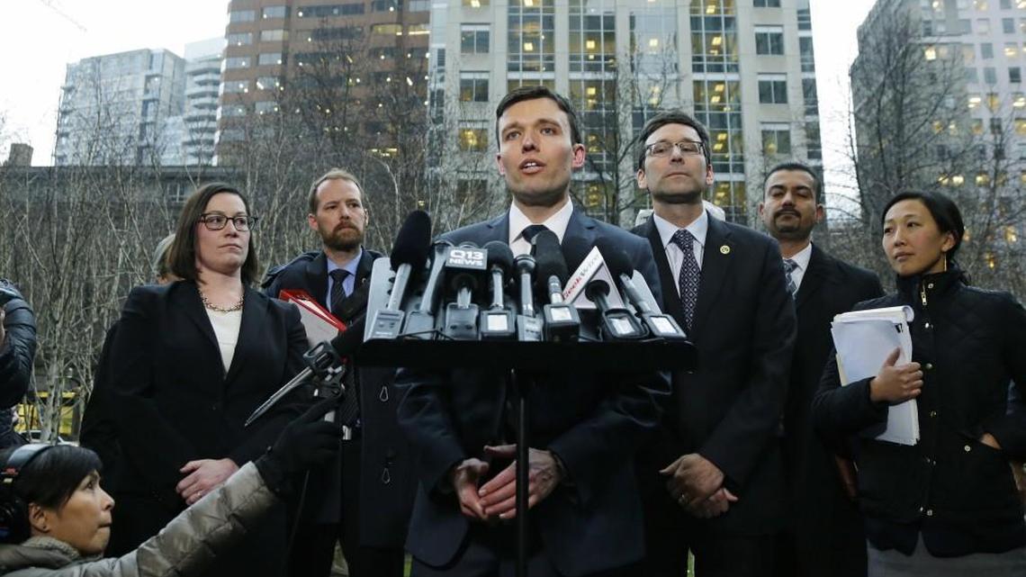 Washington state Solicitor General Noah Purcell, center, talks to reporters as Attorney General Bob Ferguson, third from right, looks on, Friday, Feb. 3, 2017, following a hearing in federal court in Seattle. A U.S. judge on Friday temporarily blocked President Donald Trump's ban on people from seven predominantly Muslim countries from entering the United States after Washington state and Minnesota urged a nationwide hold on the executive order that has launched legal battles across the country.(AP Photo/Ted S. Warren)