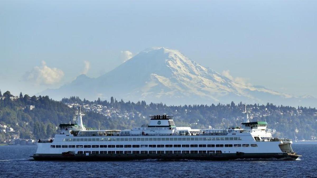 A Washington state ferry passes in front of Mount Rainier in 2014. A court fight is ending, clearing the way for a new vendor to serve food on state ferries.