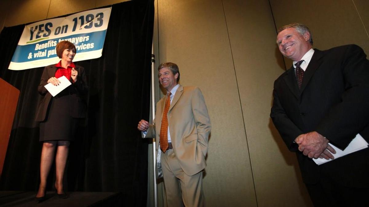 Spokeswoman Kathryn Stenger, from left, Northwest Grocery Association president Joe Gilliam, and Washington Restaurant Association government affairs head Bruce Beckett attend an election night news conference for Yes on 1183 in 2011 in Seattle.