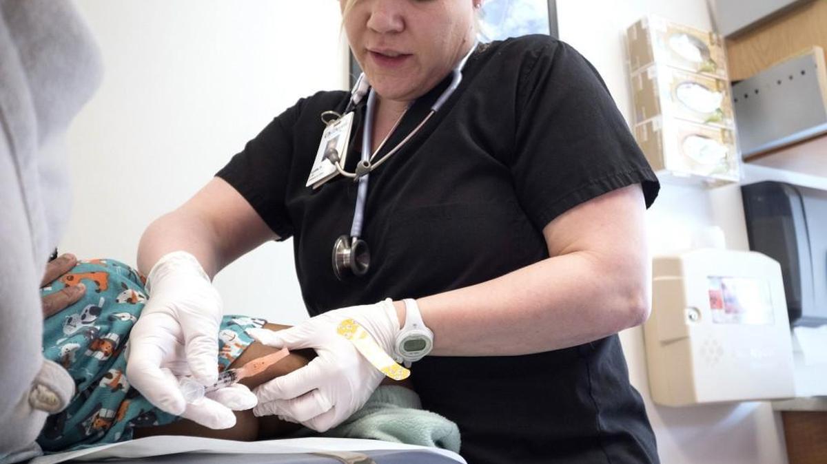 Nurse Lydia Fulton administers the vaccine for measles, mumps and rubella to a young patient at the Children's Primary Care Clinic in Minneapolis.