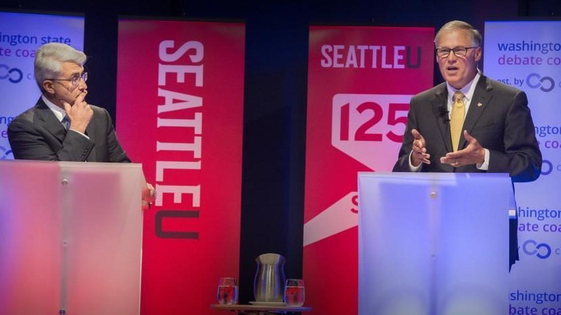 Republican Bill Bryant, left, listens intently to Washington Governor Jay Inslee making a point during the gubernatorial debate at Seattle University on Sept. 26.