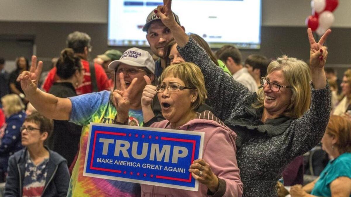 Supporters of Republican President-elect Donald Trump, flash victory signs during the Pierce County Republican Party's Election Night Party at the McGavick Conference Center at Clover Park Technical College Tuesday on Nov. 8, 2016.