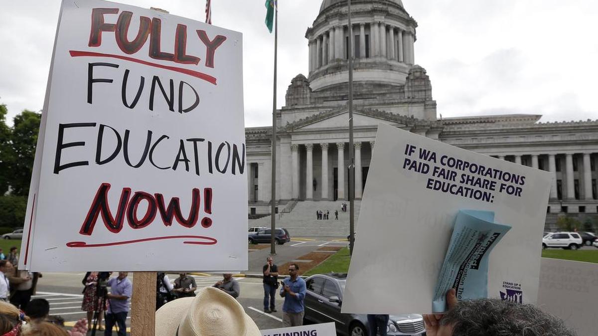 
A small group of demonstrators stands on the steps of the Temple of Justice and in view of the Legislative Building as they advocate for more state spending on education in September 2014. 
