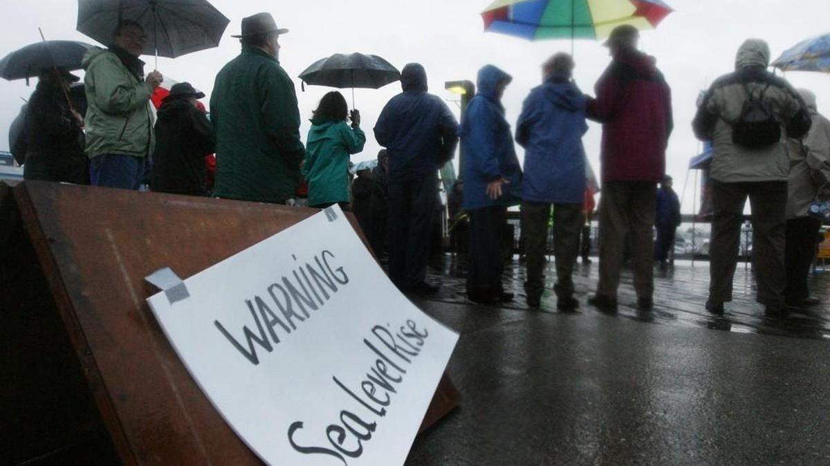 More than 100 people gathered in the pouring rain to watch the waters of Budd Inlet at the bottom of Puget Sound creep near the top of Percival Landing during a 17-foot tide. It was the type of high tide that happens a few times a year now, but will become more frequent in downtown Olympia, if sea level rise projections hold true.