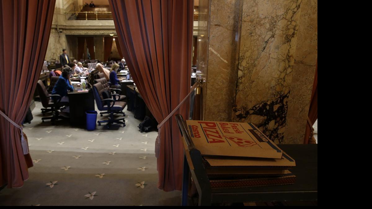 
Empty pizza boxes sit on a cart in the wings of the House chamber during a recess for caucus meetings June 30 as a session of the Washington Legislature stretches into the night at the Capitol in Olympia. Lawmakers were hoping to get a two-year state operating budget signed by Gov. Jay Inslee before midnight in order to avoid a partial government shutdown that would have started Wednesday. The Legislature has now totalled the perdiem and travel costs of its extra sessions, which are running over $440,000.

