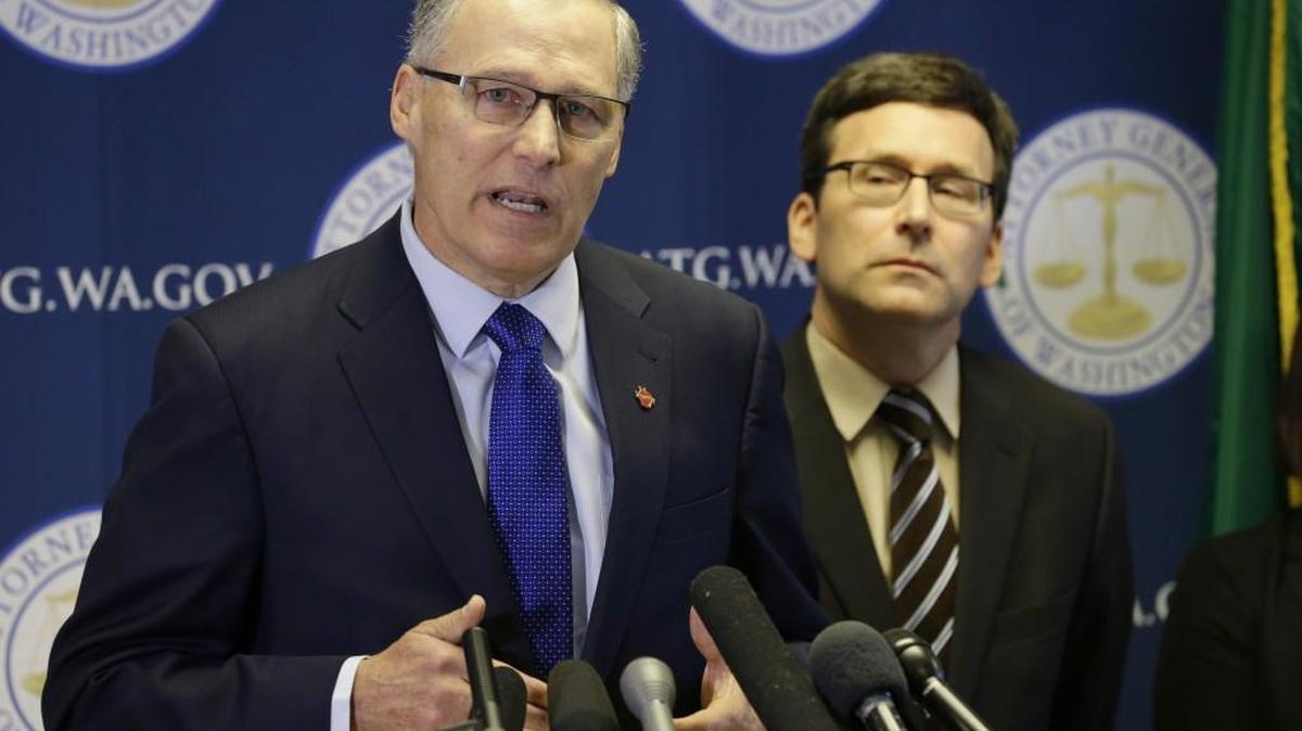 Washington Gov. Jay Inslee, left, talks to reporters as Washington Attorney General Bob Ferguson, right, looks on Monday, in Seattle. Ferguson announced he is suing President Donald Trump over an executive order that suspended immigration from seven countries with majority-Muslim populations. Ferguson and Inslee have said they have concerns about Trump’s executive order threatening to withhold money from sanctuary cities. “We’re exploring our options in regard to that issue,” Ferguson said Monday.