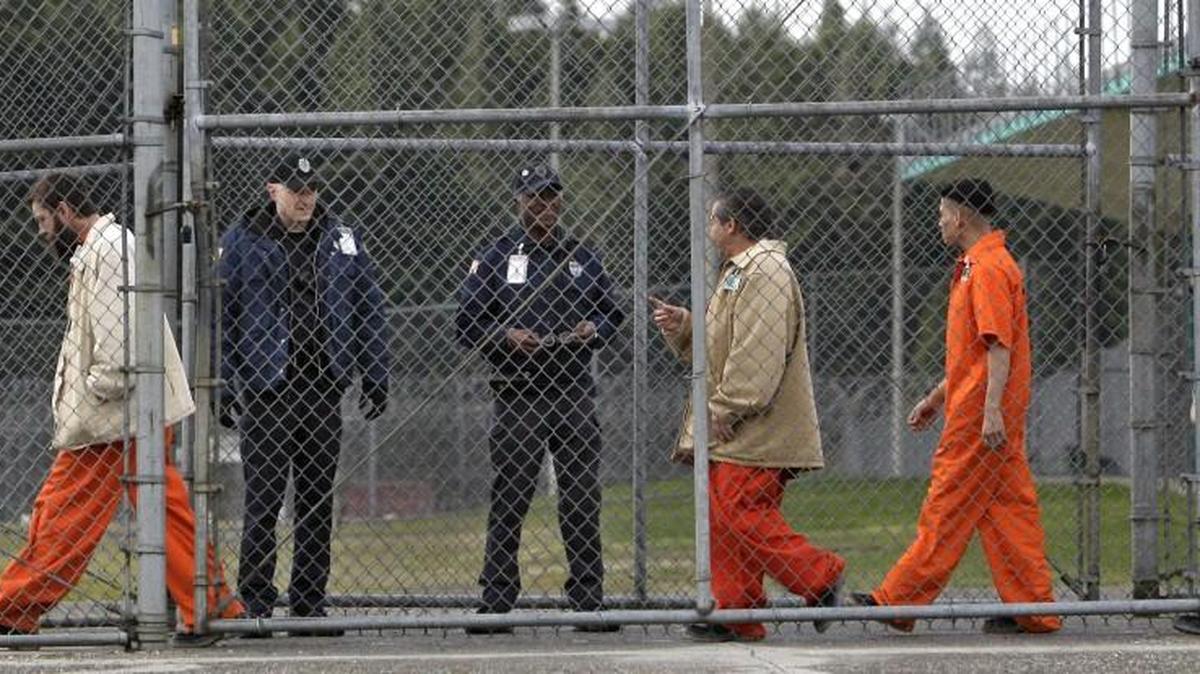 FILE - In this Feb. 17, 2011 file photo, inmates walk past correctional officers at the Washington Corrections Center in Shelton, Wash. Gov. Jay Inslee said Tuesday, Dec. 22, 2015 that more than 3,000 prisoners in Washington have been mistakenly released early since 2002 because of an error by the state's Department of Corrections.