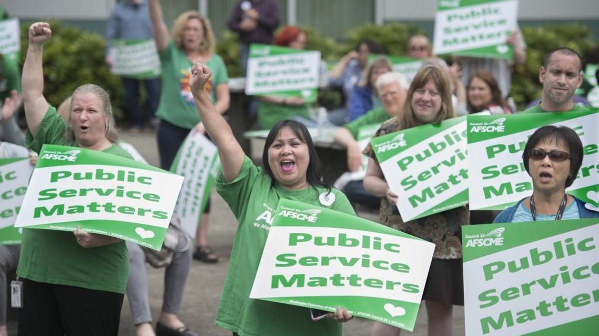 Kellie Klimcazk, left, and Diosy Page, center, cheer during a rally for the Washington Federation of State Employees at the Labor and Industries Building in Tumwater in June. Republican leaders of the state Senate are proposing to reject most of the labor contracts Gov. Jay Inslee’s office negotiated with state worker unions last summer.