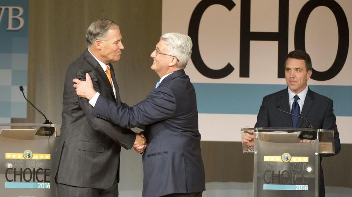 Washington Gov. Jay Inslee, left, shakes hands with challenger Bill Bryant before they debate at Spokane Falls Community College on Aug. 17 in Spokane. Moderator Sean Owsley of KHQ-TV is at right.