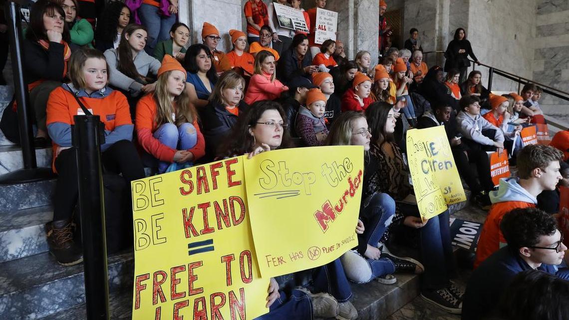 Attendees at a rally against gun violence hold signs and listen to speakers Tuesday at the Capitol in Olympia. The rally was held on the same day Gov. Inslee signed a bill into law banning the sale and possession of gun bump stocks in Washington state.