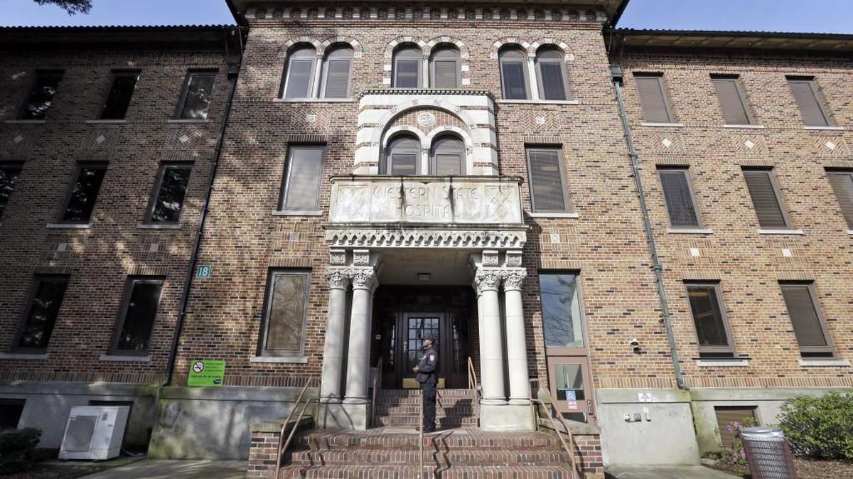 FILE - In this file photo taken April 11, 2017, a security officer stands on steps at the entrance to Western State Hospital, in Lakewood, Wash. The hospital is overseen by the Department of Social and Health Services, which is getting a new acting secretary this month. (AP Photo/Elaine Thompson, File)