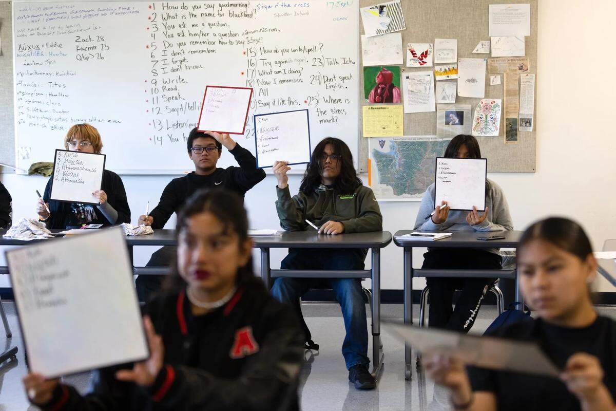Students in Roger Jacob’s Ichishkiin 4 class hold up phrases they wrote on white boards at Wapato High School on November 2, 2022.