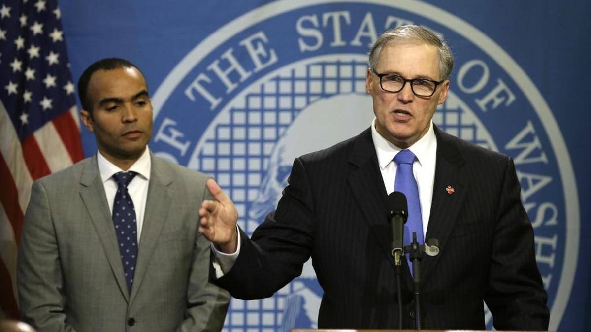 Washington Gov. Jay Inslee, right, talks to reporters Thursday, Feb. 25, 2016, as Nick Brown, left, the Governor's general counsel, looks on, at the Capitol in Olympia, Wash. Inslee released his office's nearly two-month investigation Thursday into the early release of prisoners by the Dept. of Corrections over a 13-year period.