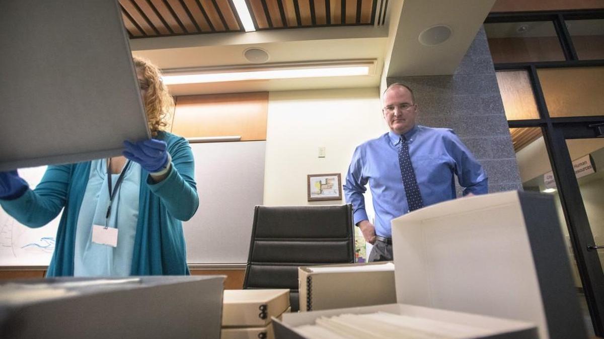 Lacey city manager Scott Pence looks over some of the estimated 80,000 pictures that his staff are pulling to fulfill a public records request for "every photo" in the city archive, shown at Lacey City Hall on Wednesday, March 8, 2017.