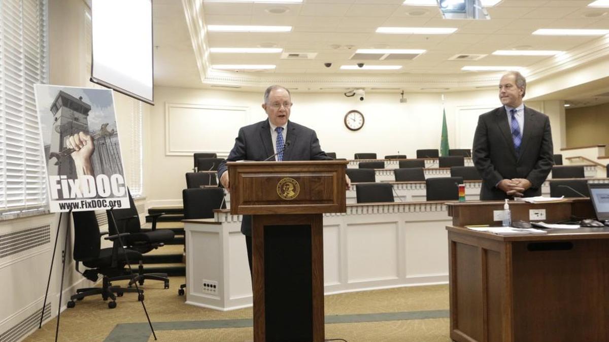 Republican Sen. Mike Padden, at podium, talks to the media about a Senate investigation into the erroneous early release of prisoners, as Republican Sen. Steve O'Ban looks on, Wednesday, May 25, 2016, in Olympia, Wash. The report casts much of the blame for the delayed fix to the error on former Corrections Secretary Bernie Warner.