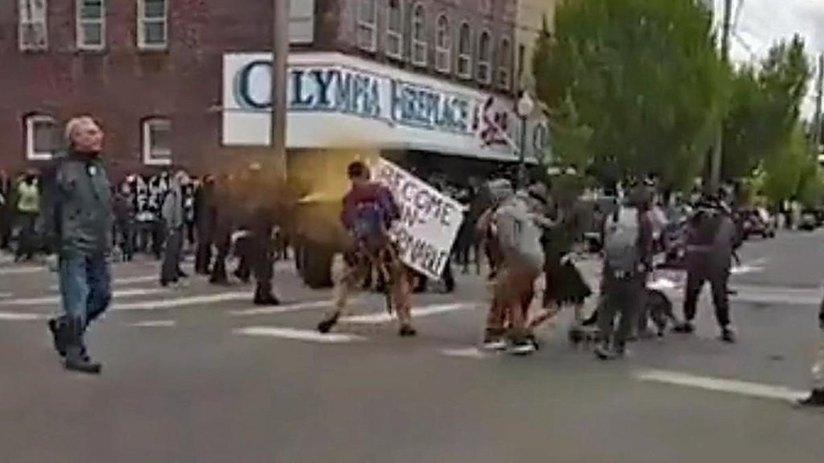 A protester uses pepper spray on a handful of people in downtown Olympia. Police arrested nine people Monday night after May Day protesters broke business windows, threw rocks at police and fought with onlookers in downtown Olympia Monday, May 1, 2017.